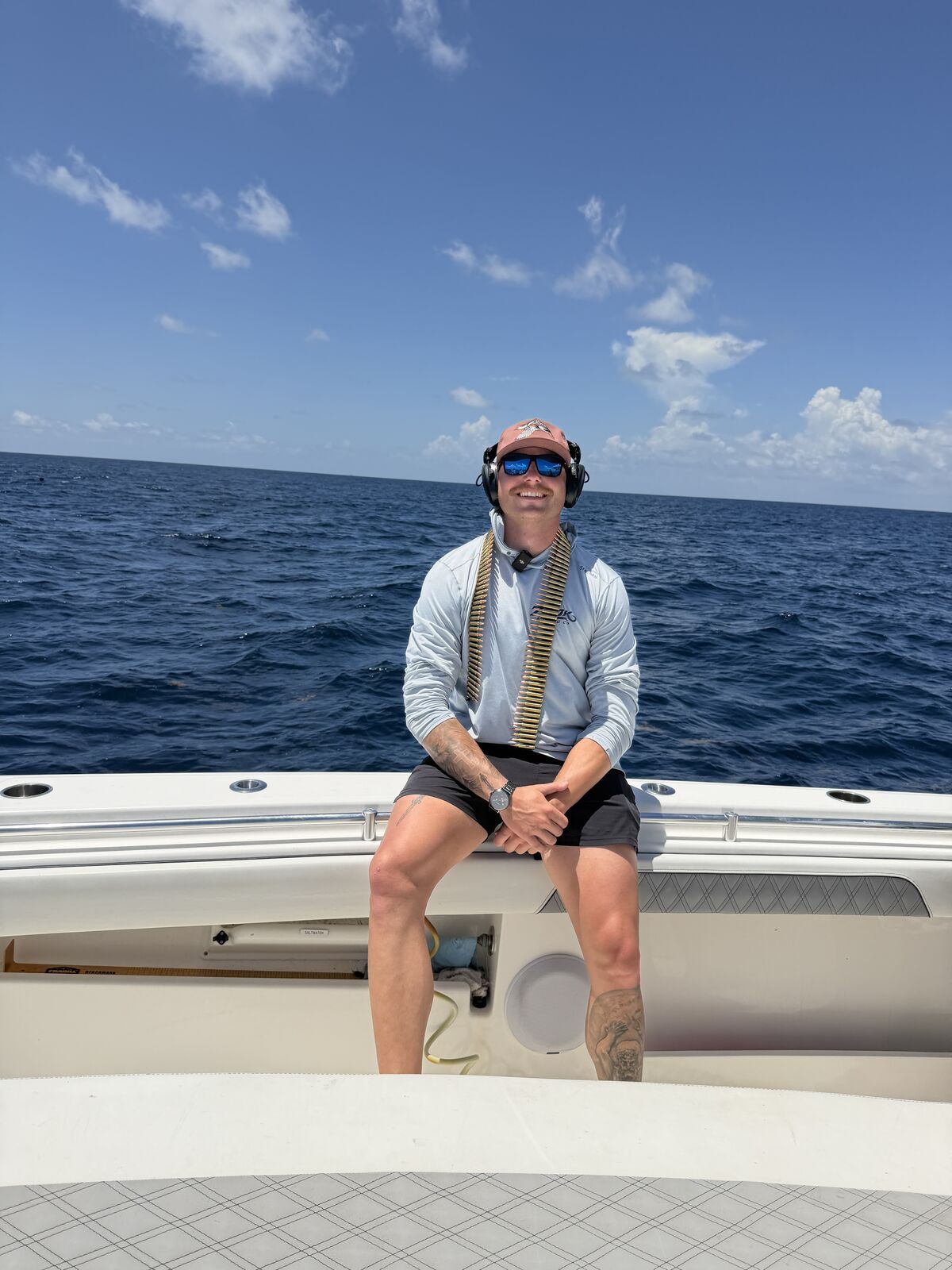 Guest seated on the bow offshore with ear protection