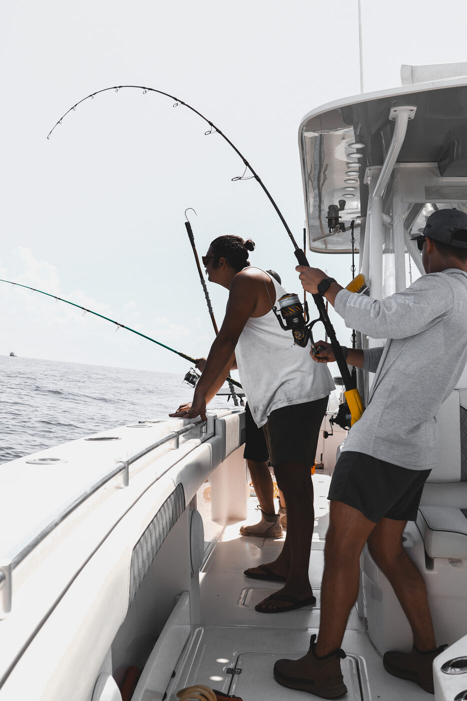 Angler leaning into a hard-fighting fish along the gunwale in the Gulf