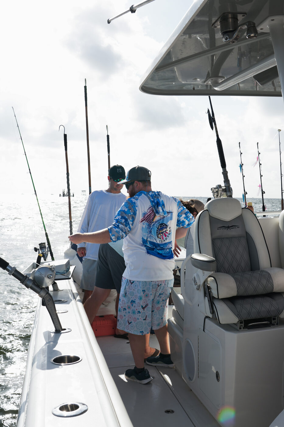 Guests working rods together on the deck of 1776 Charters offshore