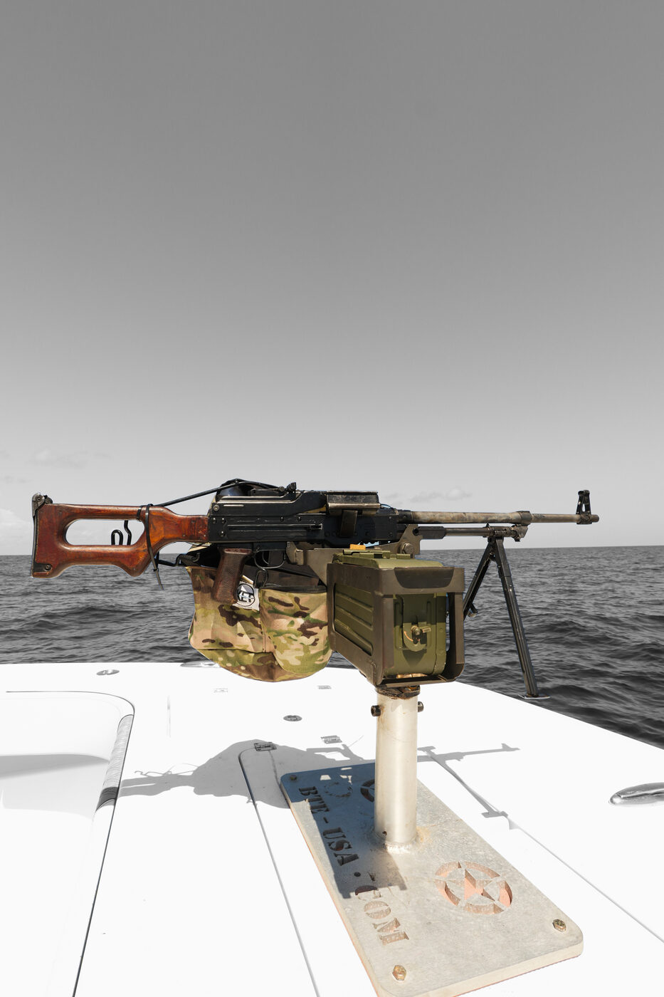 Belt-fed PKM-style machine gun with its ammo can mounted on the deck